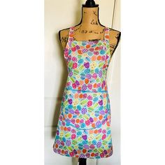 a colorful apron on a mannequin in front of a white wall and door