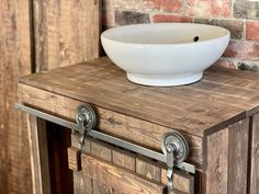 a bowl is sitting on top of a wooden cabinet with metal handles and knobs