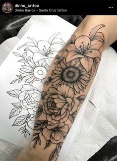 a woman's arm with flowers on it and an ink pen in the background