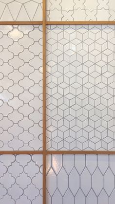 the wall is made up of white tiles and wood trimmings, with geometric designs on it