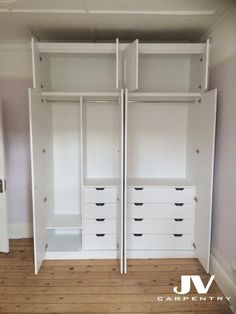 an empty room with white closets and drawers