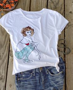 This t-shirt is unique, aesthetic and painted by artist me with a special acrylic and a brush. It also includes  some embroidery and patchwork by stitching fabrics. Express yourself with a one-of-kind aesthetic style just like I do with my painting. This shirt is purely made in USA SIZE: S   Chest: 16"   Length:21" Care of goods machine wash in cold water delicate cycle color separate tumble dry low do not bleach Casual Cotton Tops With Custom Artwork, Hand Printed Graphic Tee For Summer, Relaxed Fit Cotton Tops With Custom Artwork, Artistic Cotton Tops For Summer, White Hand Painted Top For Summer, Hand Printed Crew Neck Tops For Summer, Artsy Cotton Top With Screen Print, Crew Neck Cotton T-shirt With Watercolor Print, Artsy Cotton Tops With Graphic Print