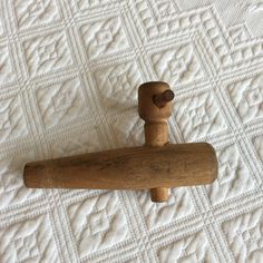 a wooden handle on top of a white quilt