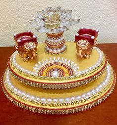 an elephant figurine is sitting on top of a decorative platter with pearls