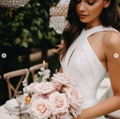 a woman in a white dress holding a bouquet of flowers