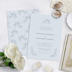 the wedding stationery is laid out on top of the table with flowers and other items