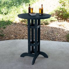 an outdoor table with two bottles of beer on it and another bottle in the background