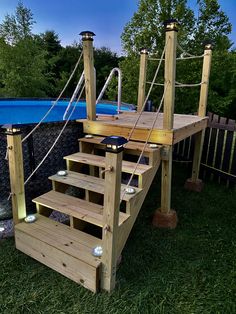 a wooden deck with steps leading up to a swimming pool