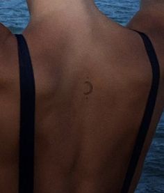 the back of a woman's head and neck, with water in the background