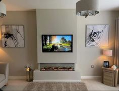 a flat screen tv mounted to the side of a wall in a living room next to two lamps