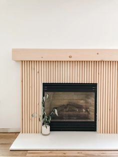 a living room with a fire place and wooden slats on the wall behind it