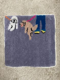 the rug is on the floor with two dogs and a person holding a dog's leash