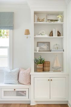 a white bookcase filled with books next to a window