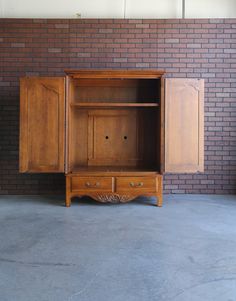 an old wooden cabinet sitting in front of a brick wall