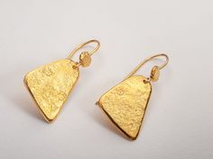 Hammered triangle drop earrings in bohemian style. Lightweight and perfect for everyday wear.  A unique and original form to bring personality and a little sparkle to your ears!  Perfect as a gift for yourself or for a loved one!  Specifications: ◈ Each triangle is 10-16mm (0.39-0.62 inches) in diameter ◈ Each earring measures 16mm (0.62 inches) wide by 35mm (1.37 inches) long.  ◈ Weight: about 5g  ◈ Material: Solid 14k gold  ◈ Nickel free. ◈ All earrings with French ear wires come with silicon backings for extra protection. In case of custom orders - please contact us for pricing. ◈ SHIPPING is insured express and free worldwide ◈ GIFT WRAPPING is included with every purchase ✧ Looking for more unique and beautiful wedding bands: https://etsy.me/32OIpT5  ✧ Back to my shop for more handcra Bohemian Gold Triangle Jewelry, Handmade Gold Triangle Jewelry, Gold Triangle Jewelry With Ear Wire, Triangle Yellow Gold Earrings For Gift, Gold Schmuck, Beautiful Wedding Bands, Gold Triangle, Gold Earrings For Women, Hammered Gold