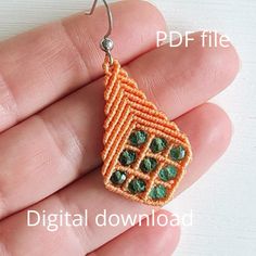 an orange and green beaded earrings on a person's hand, with the words digital