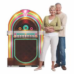 a man and woman standing next to an old fashioned juke machine