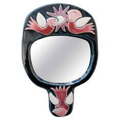 a mirror that is shaped like a bird with two hands on the front and side