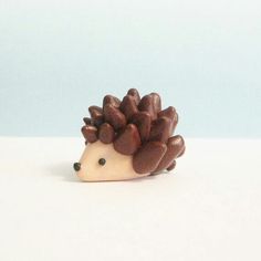 a small toy hedgehog sitting on top of a white table next to a blue wall