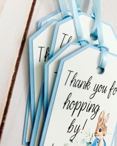 three tags with the words thank you for hopping by and a blue ribbon tied around them