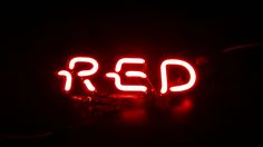 a neon sign that reads red in the dark