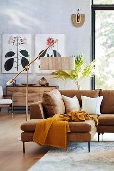 a living room with a couch, chair and lamp on the floor in front of a large window