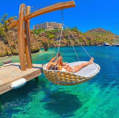 a woman laying on a hammock in the ocean