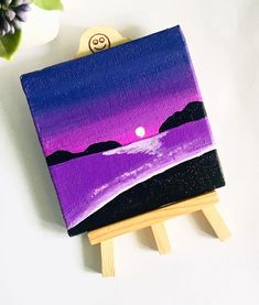 an easel with a purple painting on it