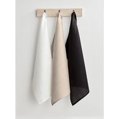 three black and white towels hanging on a wall