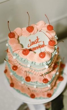 a three tiered cake with cherries on top