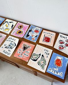 a wooden table topped with lots of different types of coasters