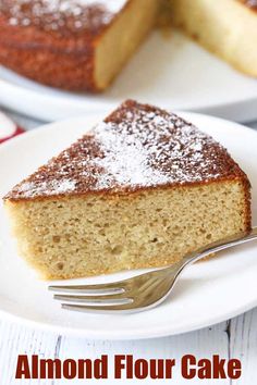 a slice of almond flour cake on a white plate with a fork next to it