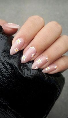 a woman's nails with white flowers on them