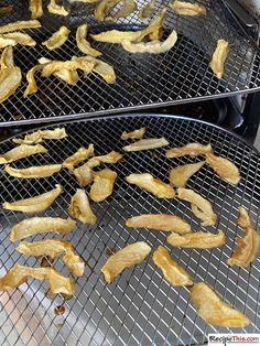 two metal trays filled with fried food on top of a stove