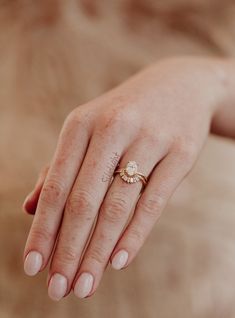 a close up of a person's hand with a diamond ring on their finger