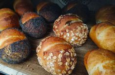 several loaves of bread sitting on top of a cooling rack with sesame seeds in them