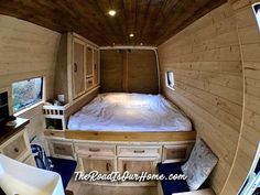 the interior of an rv with a bed, desk and television in it's center