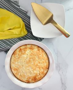 a white plate topped with a pie next to a yellow spatula on top of a table