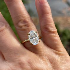 a woman's hand with a ring on it and a diamond in the middle