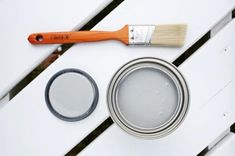 a paint can and brush sitting on top of a white wooden table next to it's primer