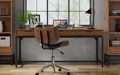 a computer desk with a laptop on top of it in front of a bookcase