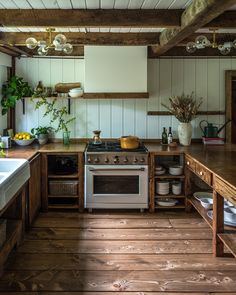 a kitchen with an oven, sink and counter top in the middle of wood flooring