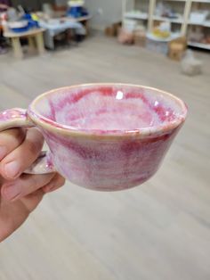 a person holding a pink and white bowl in their hand