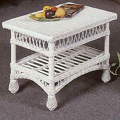 a white wicker coffee table with fruit on top