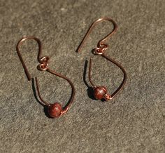 Drop Earring. Custom handmade copper metal with a red stone. Glistening with a slight sway, moderate WEIGHT, Size: 1" length by 1/2" width. Copper will age naturally, Custom hooks-ear wires: 20-guage ear wire. Copper can be mildly cleaned with a jewelry cloth. Water, perspiration, oils from hands, even storage can oxidize and tarnish any metal piece. Cleaning: Utilize a jewelry Sunshine Cloth. GENTLY polish. The cloth remains effective if one does not wash or get cloth wet. Silver-plated jewelry Hand Forged Brown Earrings As A Gift, Hand Forged Rust Earrings As Gift, Rust Hand Forged Earrings As Gift, Adjustable Rust Earrings With Ear Wire, Copper Metal, Silver Plated Jewelry, Red Stone, Pure Copper, Handmade Copper