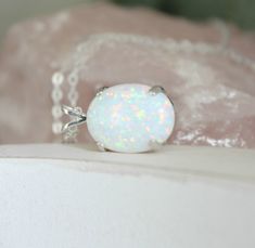 "Beautiful Large white lab-created opal pendant necklace. These gorgeous opals are very similar to natural mined opals. Lab-created opals contain 70-90% silica (from which natural opal is formed) and 10-30% resin. The resin makes the opal harder, stronger, unlike natural opals, which are known to be soft and fragile. Each opal displays a rainbow of color that sparkles with every catch of light. I've handset two different size opals in a solid sterling silver prong settings 16x12mm (5/8\" x 1/2\" White Opal Round Pendant Necklace, White Opal Birthstone Jewelry, White Opal Jewelry Gift, White Opal Pendant Jewelry, White Opal Necklace For Gift, White Opal Gemstone Necklace, White Oval Opal Necklace, Elegant White Pink Opal Jewelry, White Opal Ring As A Gift