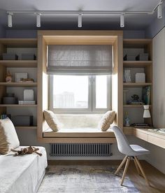 a window seat in front of a window with bookshelves on the other side