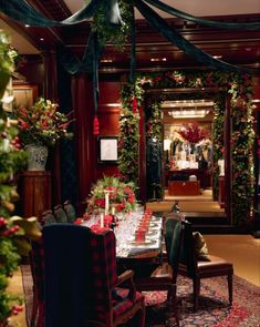 the dining room is decorated for christmas with red and green decorations, greenery and candles