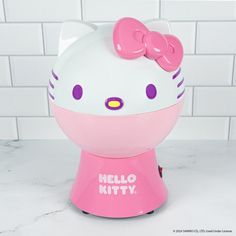 a hello kitty alarm clock is shown on a counter top in front of a white tile wall