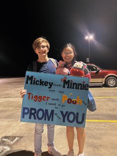 two people holding up a sign that says mickey minnie and tiger pooh from you